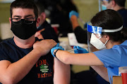 A worker of the New York City Fire Department Bureau of Emergency Medical Services (FDNY EMS) receives a Covid-19 Moderna vaccine, amid the coronavirus disease (Covid-19) pandemic in the Manhattan borough of New York City, New York, US, December 23, 2020. 