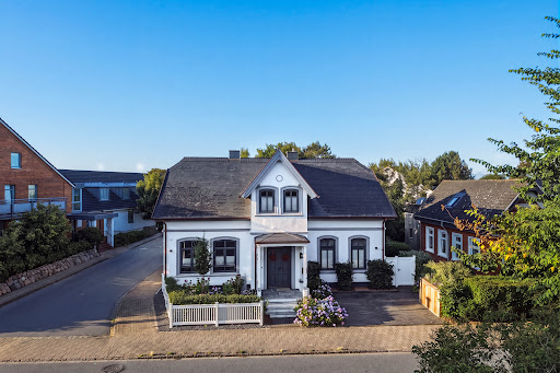 White house with flower garden in this luxury house for sale in Sylt (322 m²)
