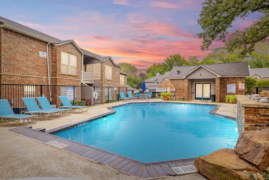 Swimming pool with lounge furniture next to apartment buildings