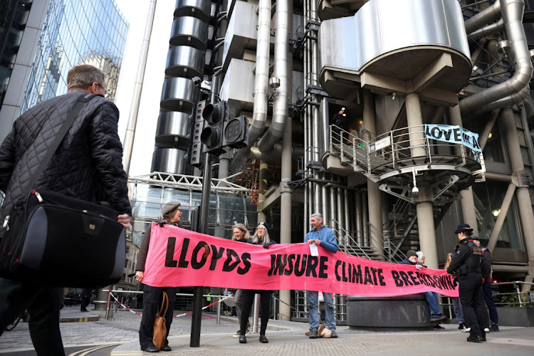 Activists from Extinction Rebellion hold a banner outside the Lloyd's of London building in the City of London financial district in London, Britain, in this April 12 2022 file photo. Picture: REUTERS/HENRY NICHOLLS