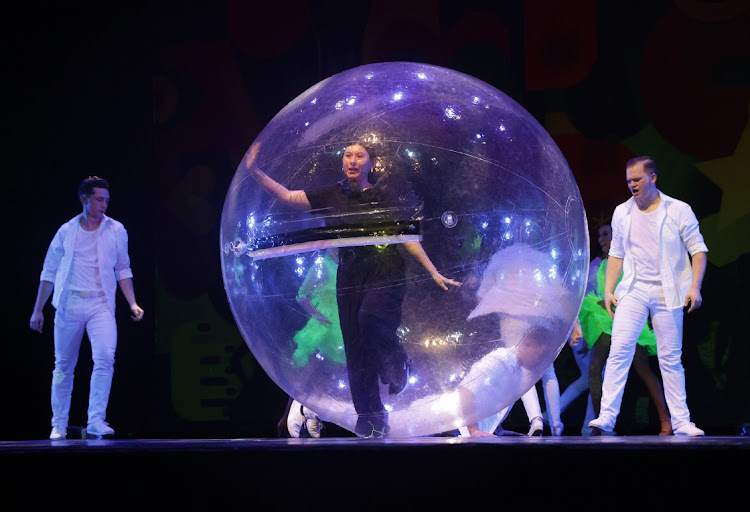 A dancer performing with an inflatable giant dancing ball to add excitement to the show.