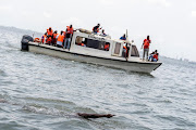 Supporters of Akinrodoye Samuel cheer while he swims in Lagos, Nigeria, on March 30 2024.