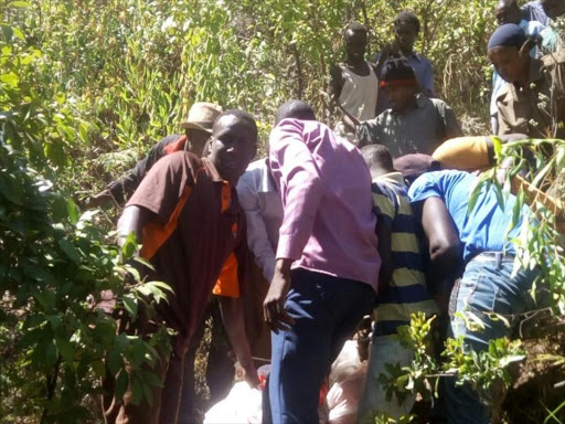 Keiyo North locals and police officers remove the bodies of two paragliders who were involved in a parachute accident on Tuesday January 23, 2018. /STEPHEN RUTTO