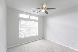 Bedroom with light carpet, gray walls, a large window, and ceiling fan