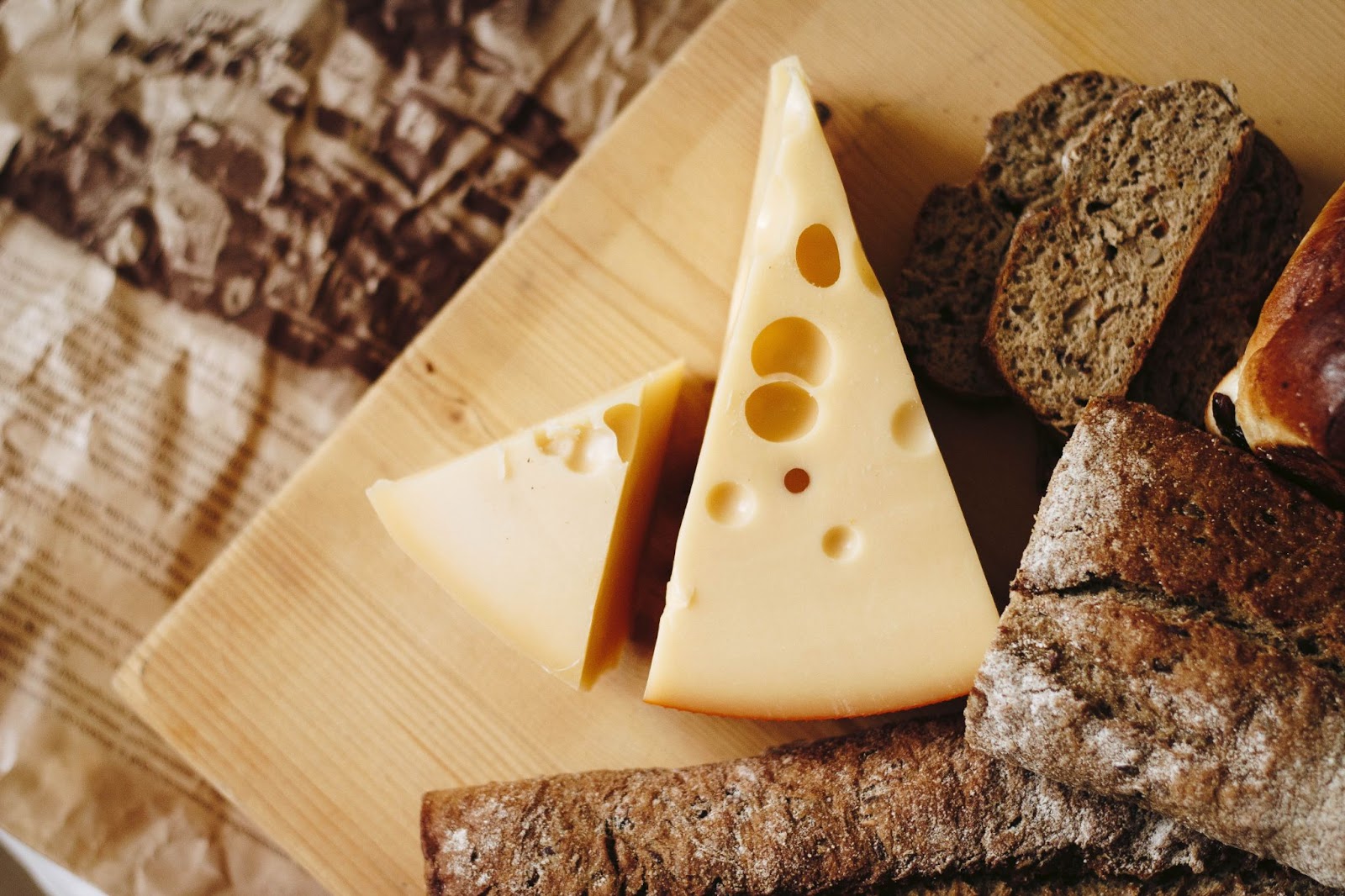 Cheese blocks on a board with bread