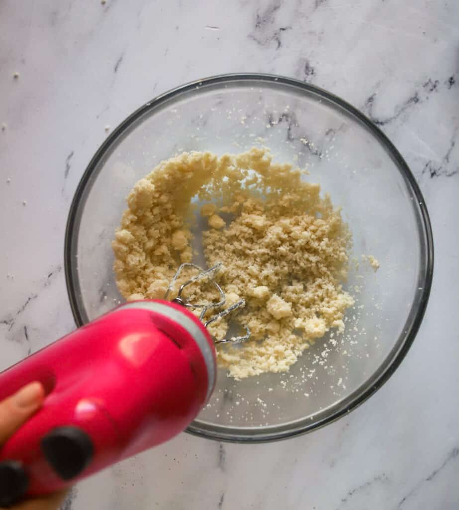 pink hand mixer creaming butter and sugar together