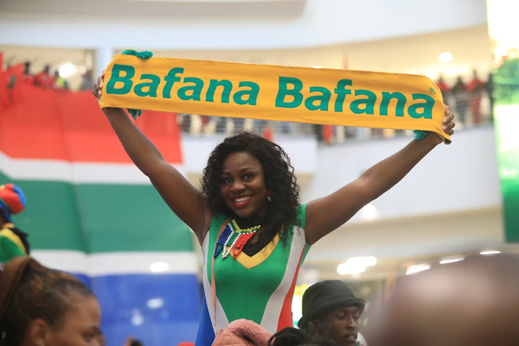 A Bafana Bafana fan holds up a banner with the national team's name as scores flocked OR Tambo International Airport to welcome the team.