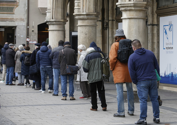 Visitors queue for Covid-19 vaccinations outside the town hall in Munich, Germany on November 15 2021. A surge in infections is threatening the country's Christmas season economic growth. Picture: BLOOMBERG/MICHAELA HANDREK-REHLE