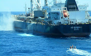 Salvors watch from a rigid inflatable as the NS Qingdao's smouldering chemicals are dumped over the side of the bulk carrier 250km off the west coast.