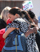 Meghan, Duchess of Sussex, receives a hug from a wellwisher as she visits a Justice Desk initiative in Nyanga township on September 23 2019 in Cape Town.