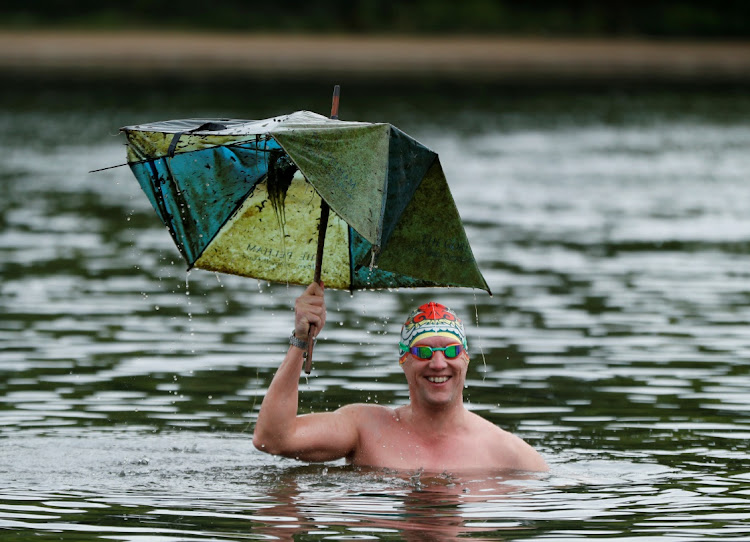 A member of the Serpentine swimming club poses with an umbrella he found in the Serpentine Lake in Hyde Park prior to it's official reopening on Monday, following the outbreak of the Covid-19 coronavirus, London, Britain, on May 16, 2020.