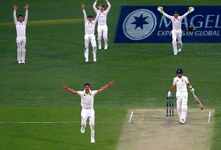 Australia's Pat Cummins appeals with team mates for LBW to dismiss England's Joe Root during the first day of the first Ashes cricket test match.