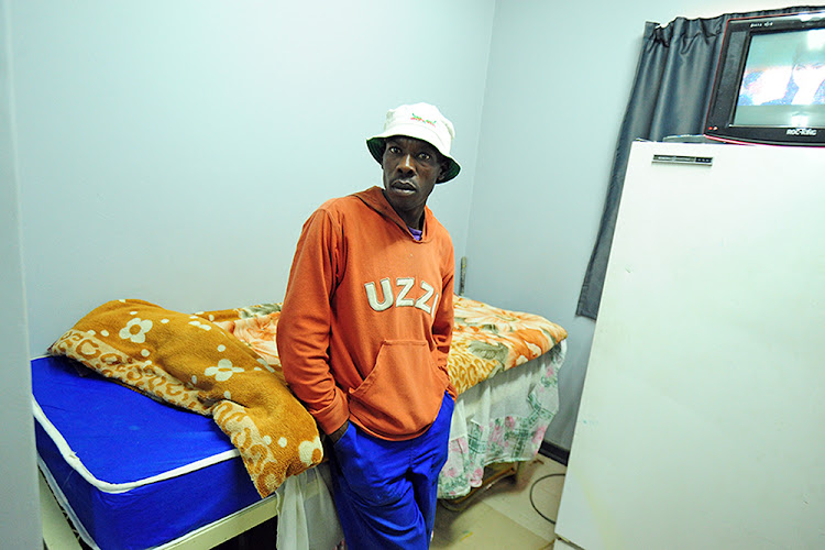 Johannes Honono stands next to a bed in the hostel he lives in at Rantjiespark horse stables. The labour department visited the stables on Tuesday to check on compliance by trainers and to talk to horse grooms about their rights.