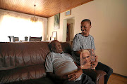 Vinolia Mashego's son Oratile,  with his grandfather Collins Mashego, holds up a picture of his mom and the Jam Alley star. / Thulani Mbele