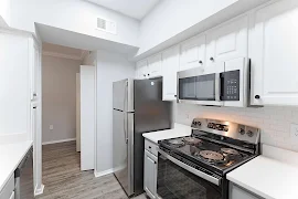 Galley style kitchen with stainless steel appliances, white countertops with white subway style tile backsplash