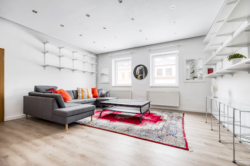 Modern living room with grey sofa and red rug in this luxury house for sale in Prague ($1,311,079 - 200 m²)