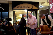 Author Jacques Pauw (in striped shirt) prior to the official launch of his book The President's Keepers at Exclusive Books in Hyde Park, Johannesburg.
Image: ALON SKUY