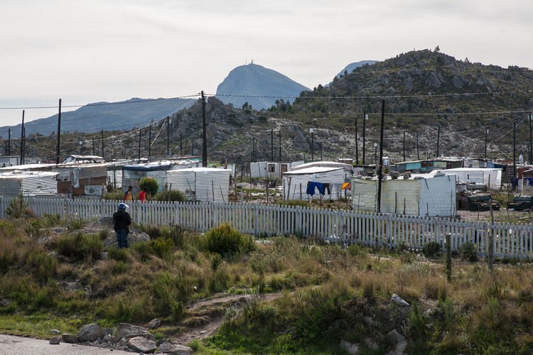 A police officer monitors an informal settlement in Grabouw alongside the N2 near Sir Lowry’s Pass after striking farm workers and their supporters blocked the road.