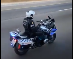 A traffic officer on a motorcycle who let go of his handlebars and appeared to be grooving to music while on the job is facing a disciplinary hearing after being caught on camera.