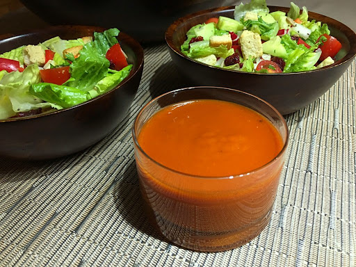 A dressing with two salad bowls in the background.