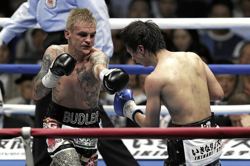 Hekkie Budler, left, punches Ryoichi Taguchi of Japan during their IBF & WBA light flyweight bout at Ota City on May 20.