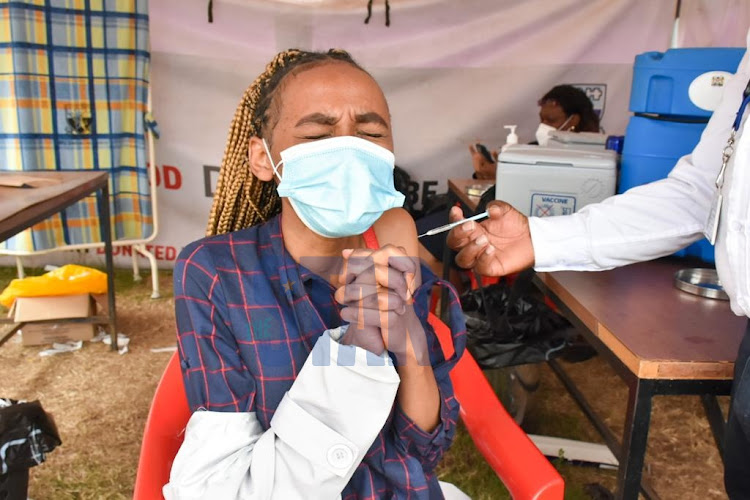 Diana Njeri reacts while receiving a dose of COVID-19 AstraZeneca vaccine during a mass vaccination on August 8,2021 at KNH. The vaccination is meant to slow down and prevent the spread of Covid-19./MERCY MUMO