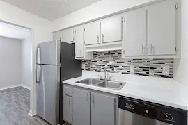 Kitchen with light gray cabinet doors, stainless steel appliances, and tiled backsplash