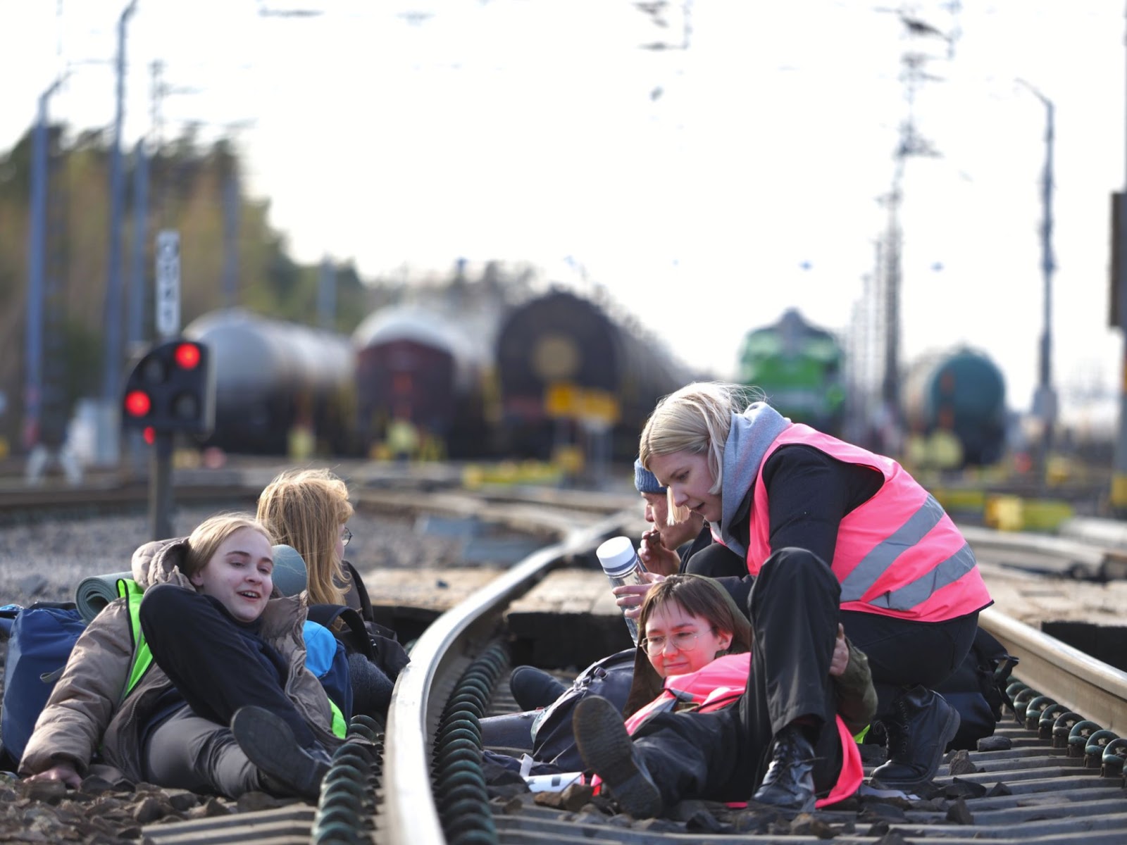 Finnish rebels lie and sit locked on to train tracks outside oil refinery