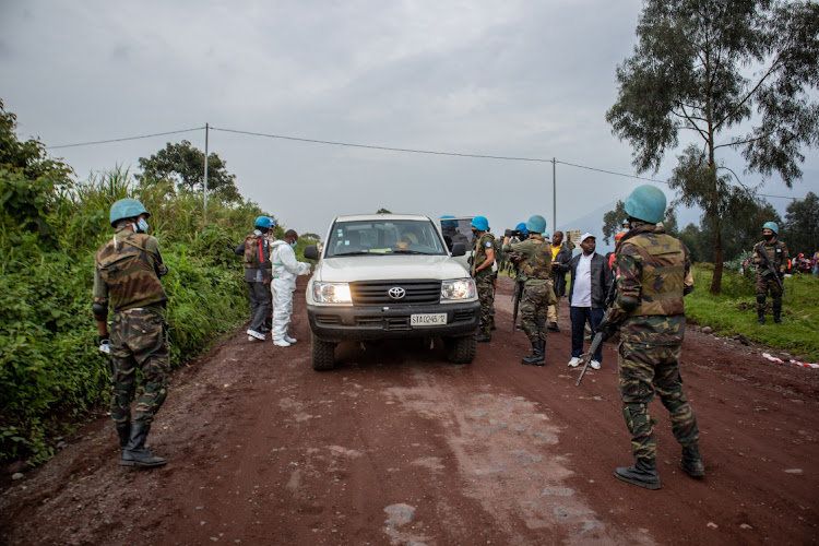 Officials inspect the vehicle in which Luca Attanasio and his team were travelling. Attanasio, bodyguard Vittorio Iacovacci and their driver Mustapha Milambo were killed during a botched kidnapping in eastern DRC. Picture: GETTY IMAGES/GUERCHOM NDEBO