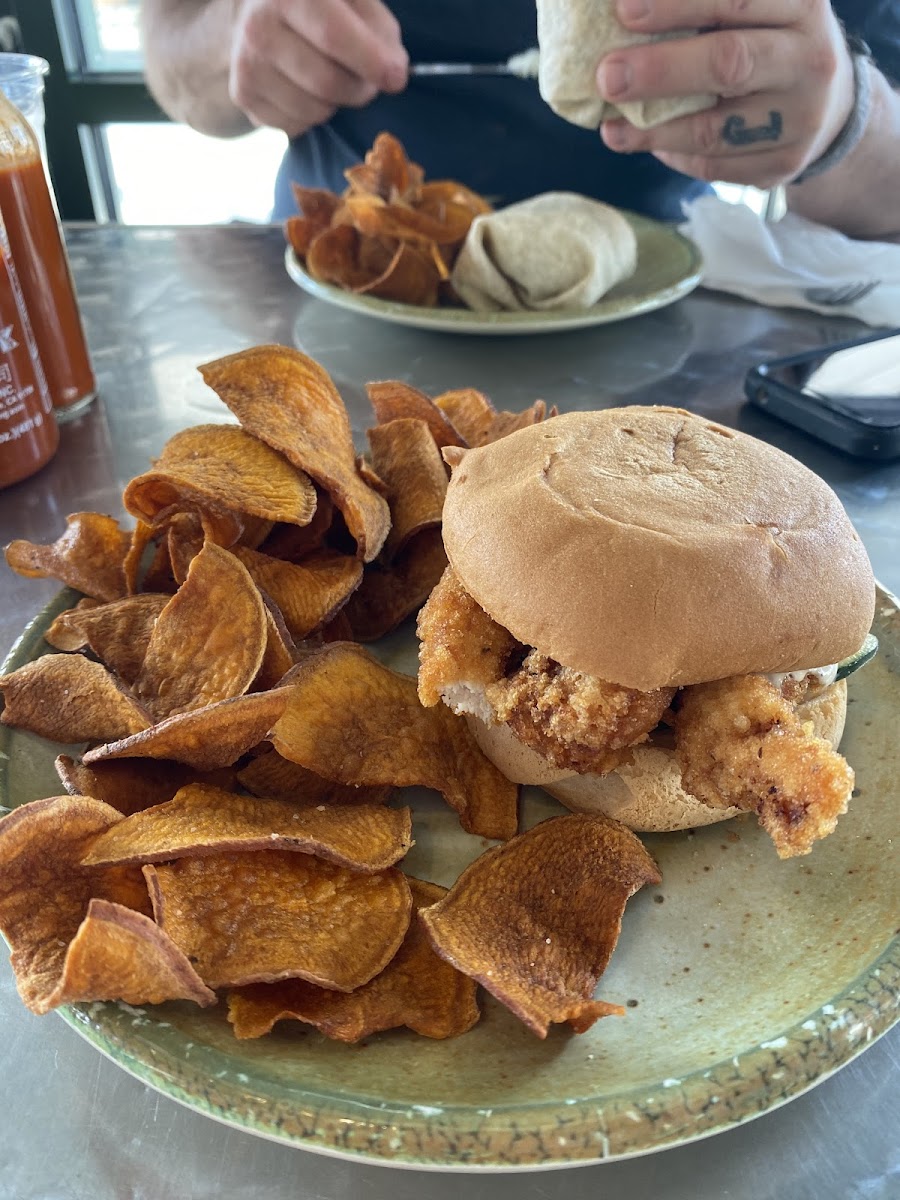 Fried chicken sandwich on GF bun, in-house ranch and pickles, with a side of sweet potato chips!