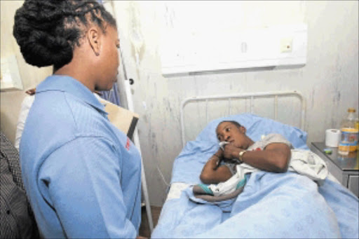 SURVIVOR: Westonaria mayor Maphelo Letsie-Mogare visits Realeboga Letsala in hospital after he was shot in the attack at the tavern. PHOTO: VELI NHLAPO