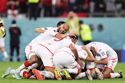 Wahbi Khazri of Tunisia is mobbed by team mates after he scored for his side against France during their FIFA World Cup Qatar 2022 Group D match at Education City Stadium on November 30, 2022 in Al Rayyan, Qatar.