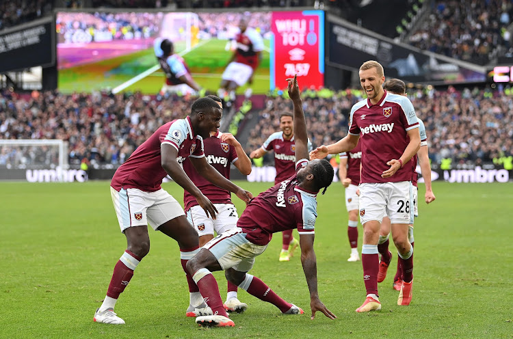 Striker Michail Antonio celebrates with his West Ham United teammates after scoring the only goal of the match.