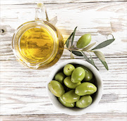 Jug of olive oil with a bowl of olives.