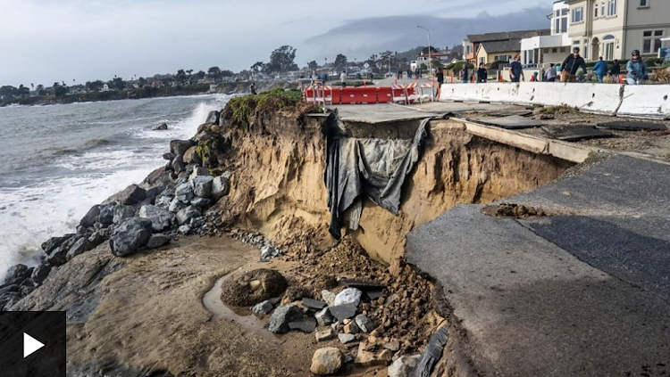 Uprooted trees and flooded street in California