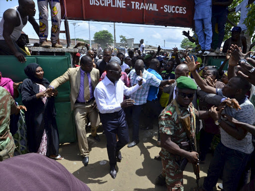 Benin Presidential candidate Patrice Talon (C, in white) arrives at a polling station during presidential elections in Cotonou, Benin, March 20, 2016.