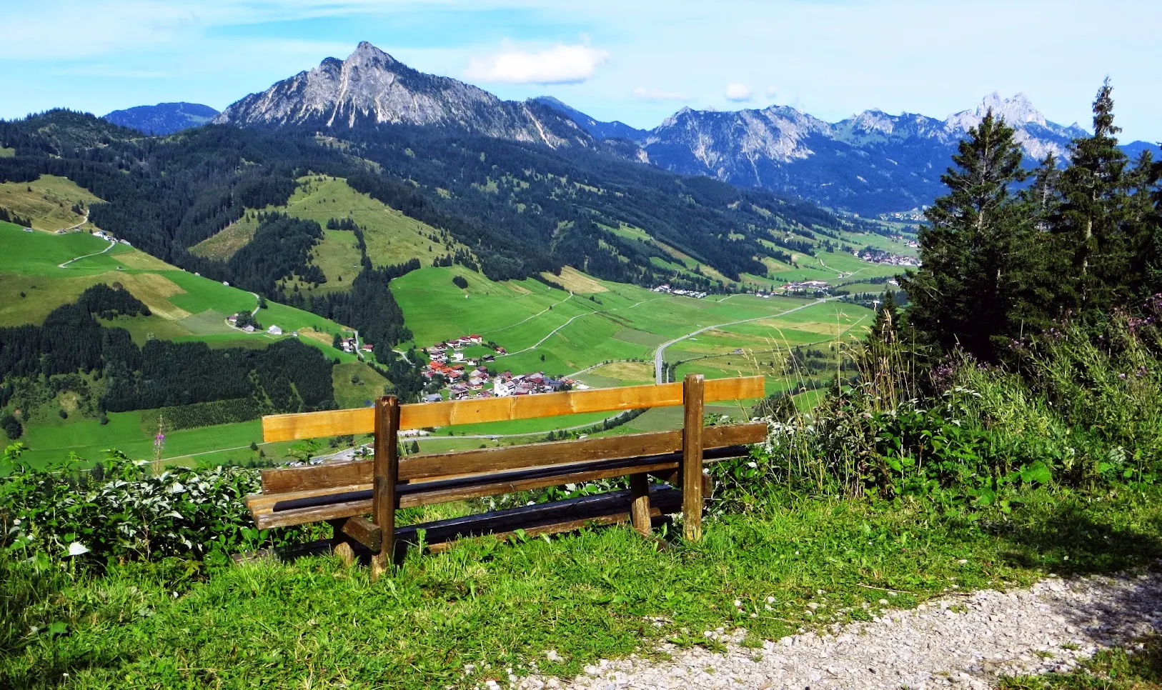 Foto: Bequemer Weg hinab ins Tannheimer Tal, Tirol, Rastbänke an den schönsten Ausblicken, wie hier zum Einstein links, Gimpel und Rote Flüh rechts