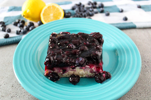 A slice of Blueberry Cream Cheesecake on a plate.