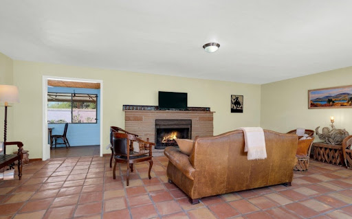 Living room with fireplace and leather furniture in this luxury house for sale in Tucson ($550,000)