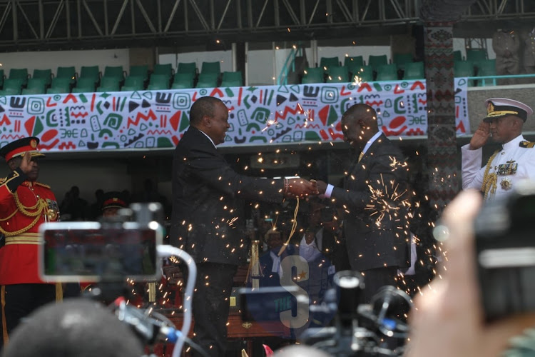 Outgoing president Uhuru Kenyatta with President William Ruto after handing over I instruments of power at Kasarani stadium on September 13,2022.