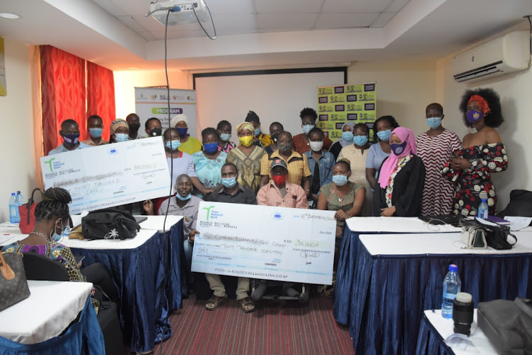 Representatives of the 12 awardees with CWID members, group chairperson Maureen Mudi and executive director Betty Sharon during the handing over of Sh30,000 cheques from the Agha Khan Foundation.