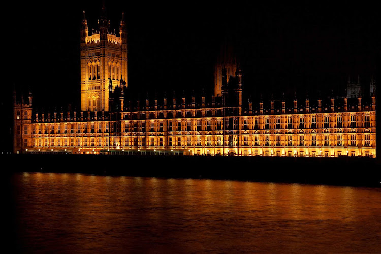 The Parliament building lit up at night on the River Thames in London. 