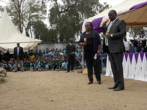 Mavoko MP Patrick Makau (R) addresses the public after he commissioned two CDF funded classrooms at Mavoko Primary School in Athi River on Friday.