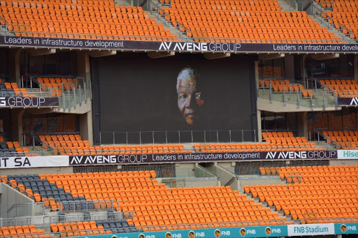 A portrait of former president Nelson Mandela is shown on a giant screen at the FNB Stadium (Soccer City) on December 9, 2013 during preparations ahead of Mandela's memorial service in Johannesburg on December 10.