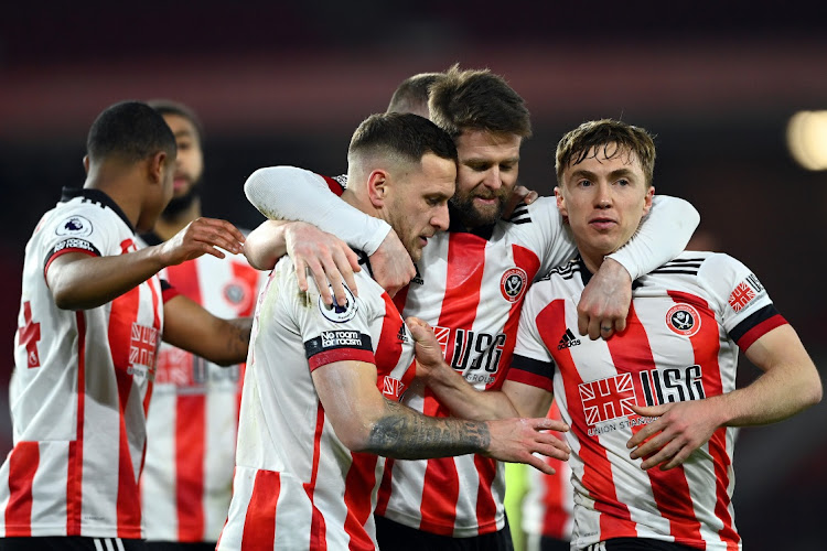 Billy Sharp, of Sheffield United, left, celebrates with Oliver Norwood centre and Ben Osborn after scoring a penalty in the side's first win in 186 days in the Premier League match against Newcastle at Bramall Lane on January 12, 2021 in Sheffield