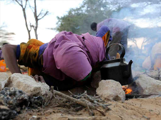 An internally displaced Somali woman prepares tea at a resting site as she flees from drought stricken regions in Lower Shabelle region before entering makeshift camps in Somalia's capital Mogadishu, March 17, 2017. /REUTERS