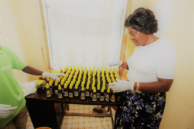 Kitui Governor Charity Ngilu admires packaged honey at the Kamaki bee keepers Kamaki bee keepers manual honey refinery in Athi ward Kitui county last Friday.