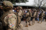 Republican guard form a security cordon, as supporters of Democratic Republic of the Congo's President Felix Tshisekedi cheer for him, after he cast his vote at a polling station, during the presidential election, in Kinshasa.