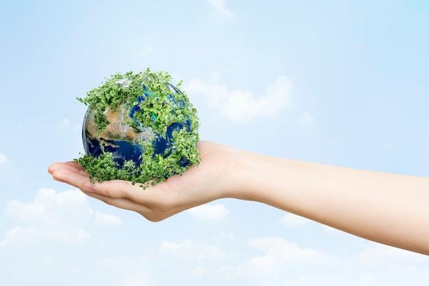 Sustainable living environmentalist hand holding green earth Free Photo