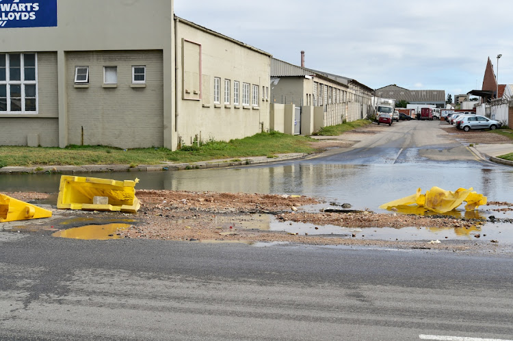 Mangled plastic barriers knocked out the way by night-time trucks lie in the large pool of sewage welling out of Burman Road on the corner of Adolf Street